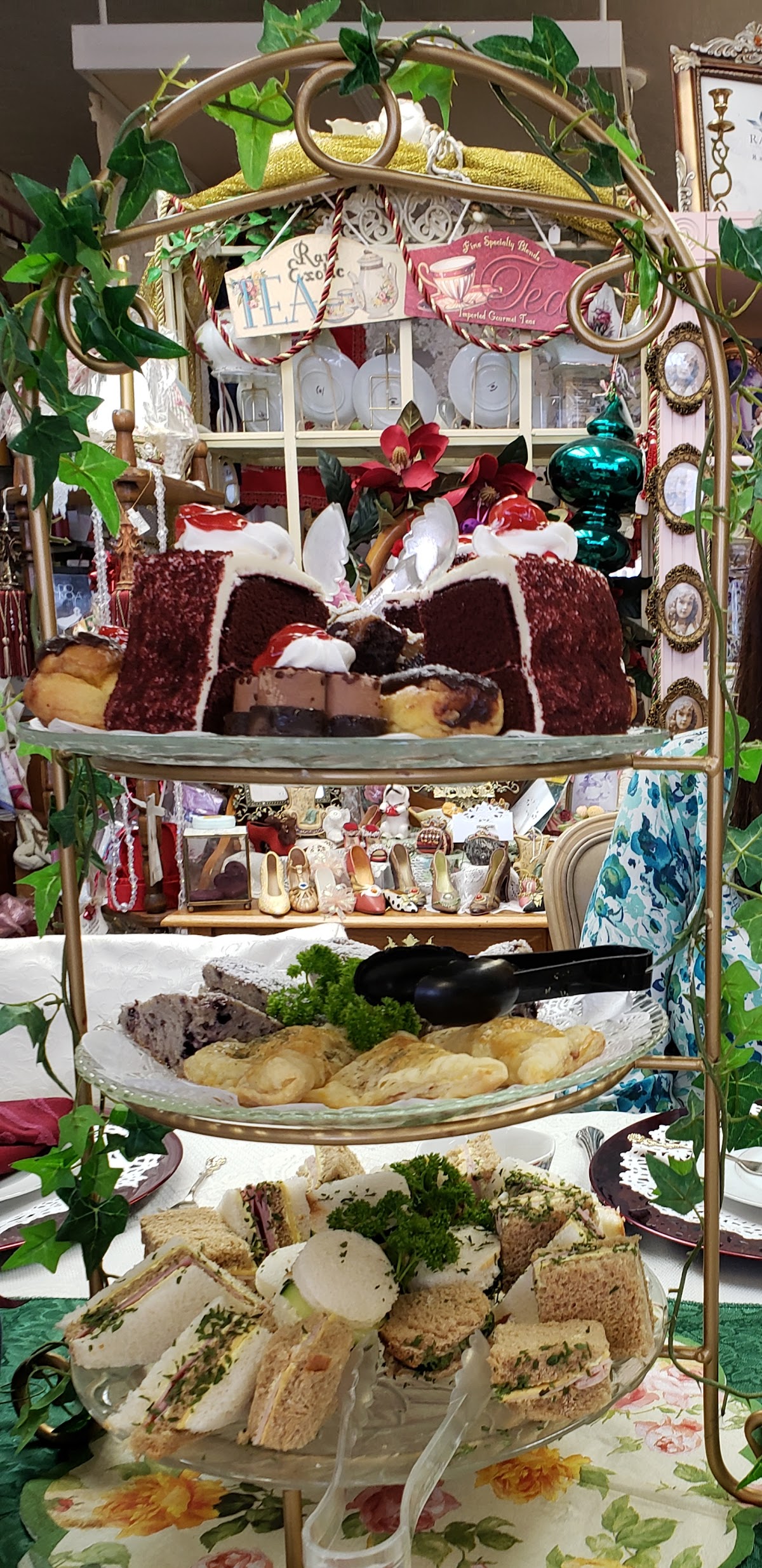 A tiered afternoon tea stand at Victorian Connection with cake, scones, and tea sandwiches