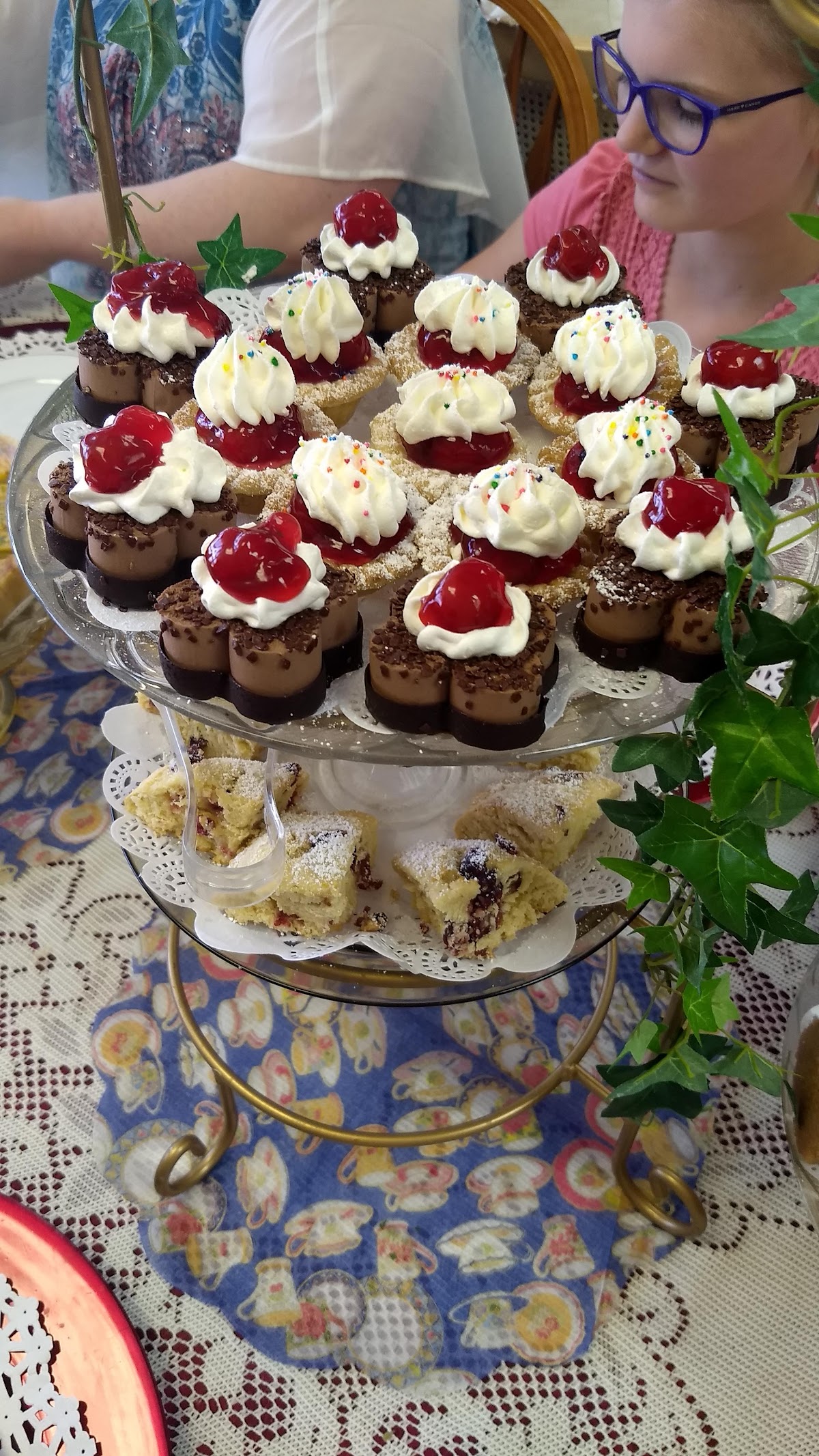 Chocolate and cherry mini cakes on a glass cake stand